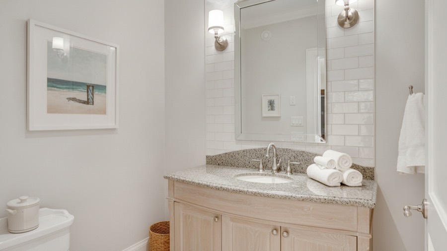 The same bathroom redesigned into a bright coastal bathroom with washed timber, white tile and brushed nickel